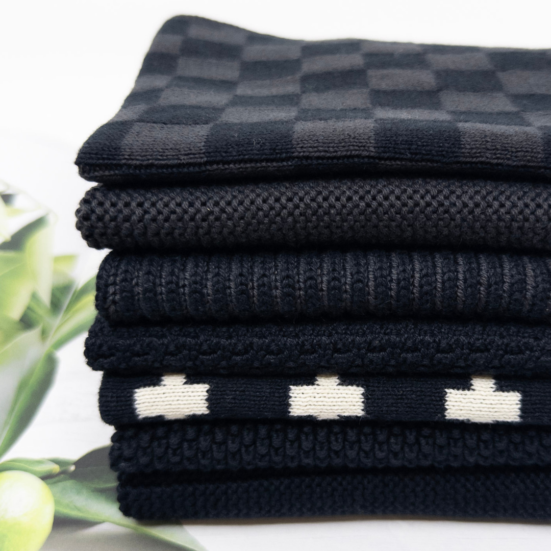 Stack of folded black and white checkered dishcloths on a white background