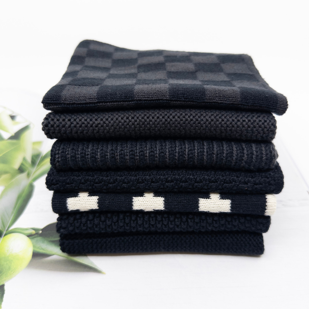 Stack of folded black and white checkered dishcloths on a white background