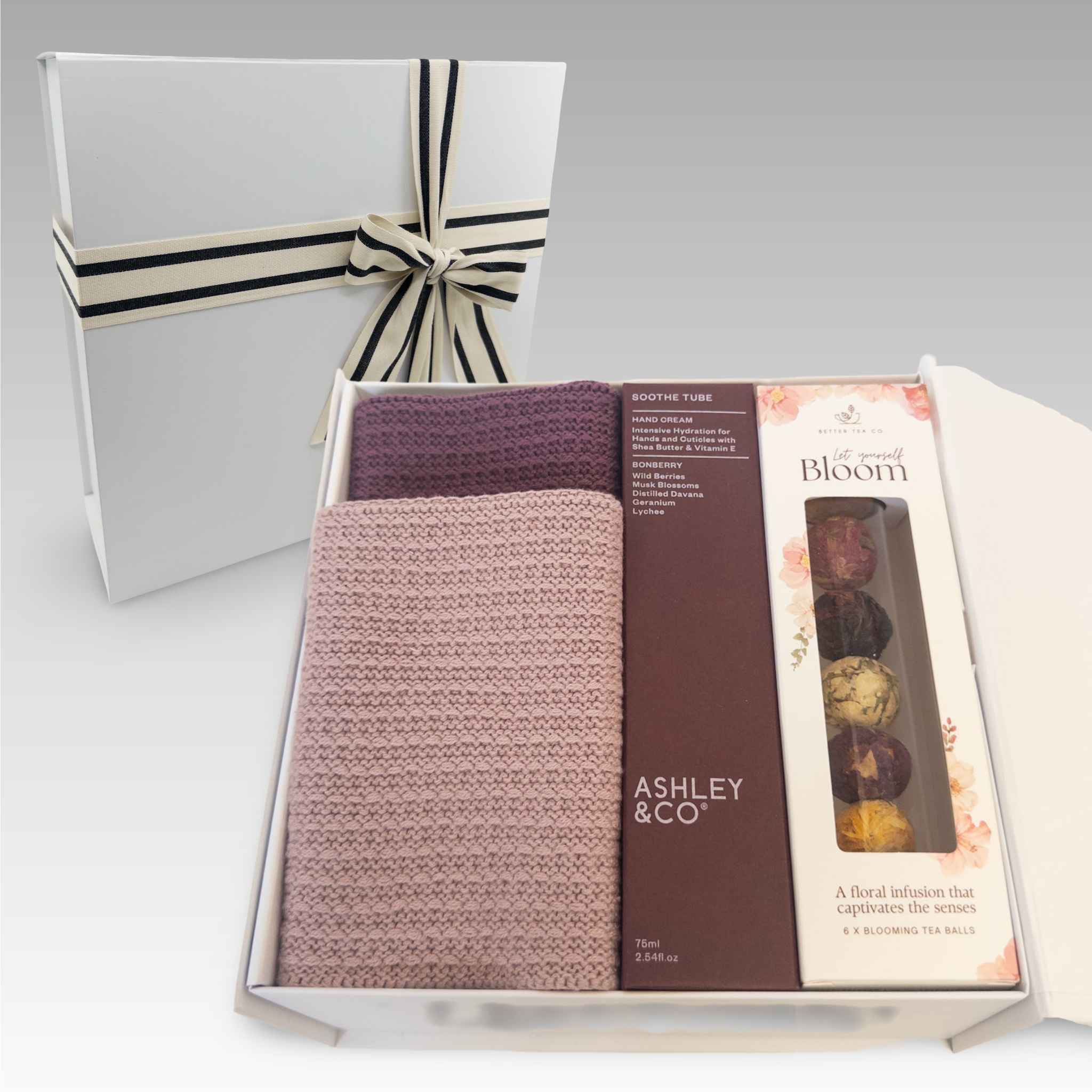 Gift box with 2 organic cotton facecloths, an 'Ashley & Co' Sooth Tube and a pack of Blooming Tea Balls. 
